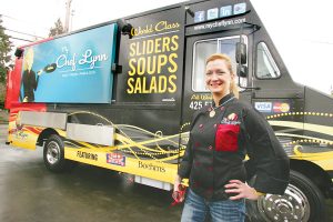 By Greg FarrarLynn Rehn stands beside her My Chef Lynn food truck, advertising its ‘fast, fresh, fabulous’ sliders, soups and salads, featuring items from Issaquah businesses Fischer Meats and Boehm’s Candies.